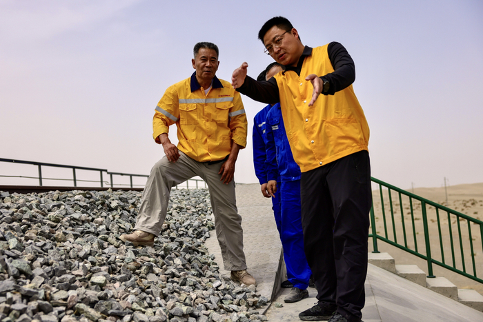 胡国星（右一）与同事们在施工现场交流。受访者供图