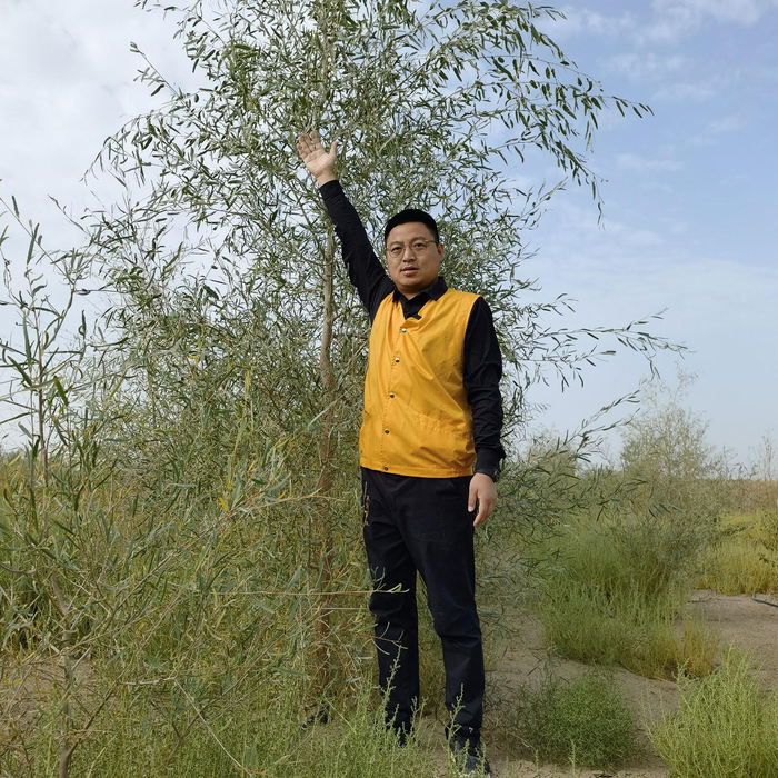 胡国星与长高的胡杨合影。受访者供图