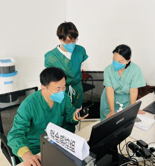      杨帆（左一）对感控组工作进行指导    