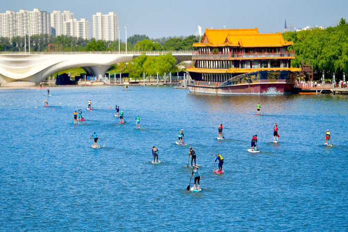 桨板选手们在运河上奋力划桨。 记者 常鸣/摄
