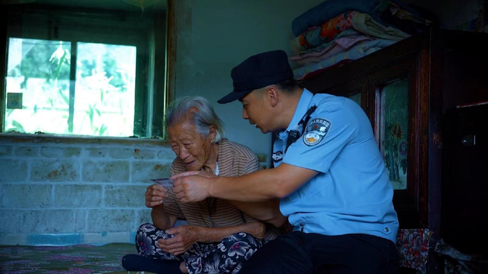 张宇航上门看望老人，发放警民联系卡。受访者供图