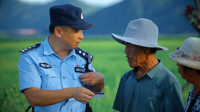 张宇航走村入户发放警民联系卡。受访者供图