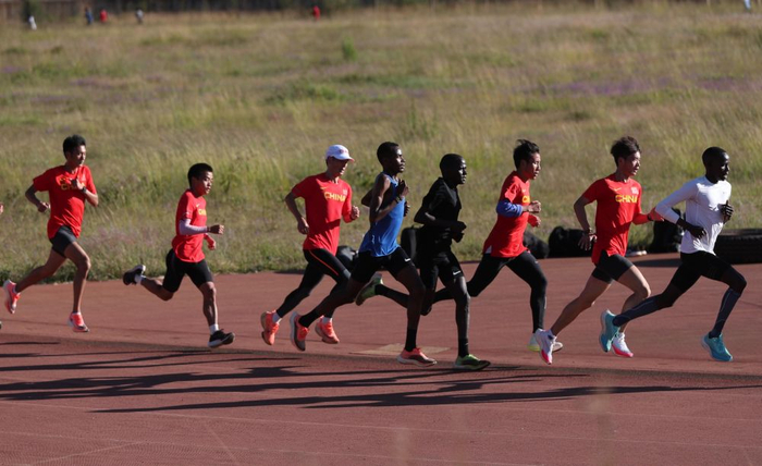 9月27日，中国男子马拉松集训队队员与当地运动员一起训练。新华社记者龙雷摄