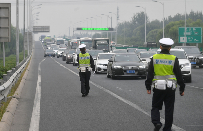 今天早上，交警在京承高速主线收费站前严查占用应急车道行为。新京报记者 王贵彬 摄