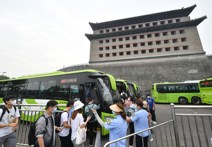 工作人员提醒乘客提前打开相关乘车APP或出示北京健康宝。新京报记者 王贵彬 摄