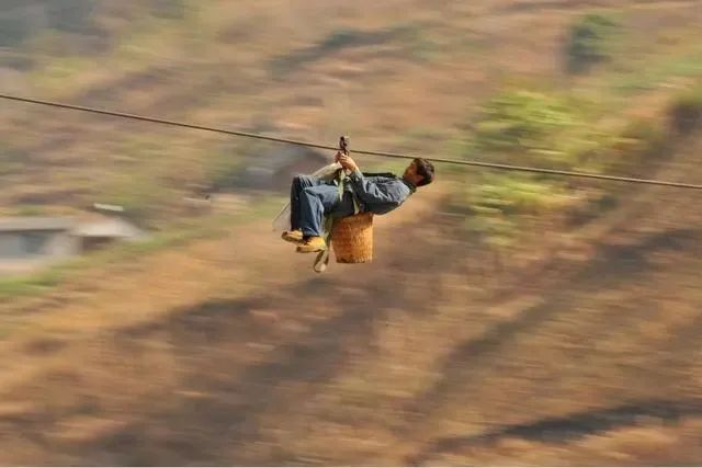 2013年2月2日，在怒江州六库镇双米地村辣子咪村民小组，一名村民背着背篓过溜索。新华社记者 王长山 摄