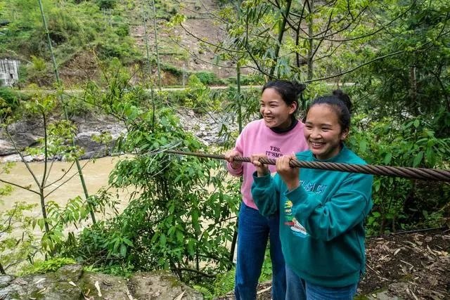 2022年4月10日，余春花（左）和余才妹（右）站在曾经一起过江的溜索旁。新华社记者 王安浩维 摄