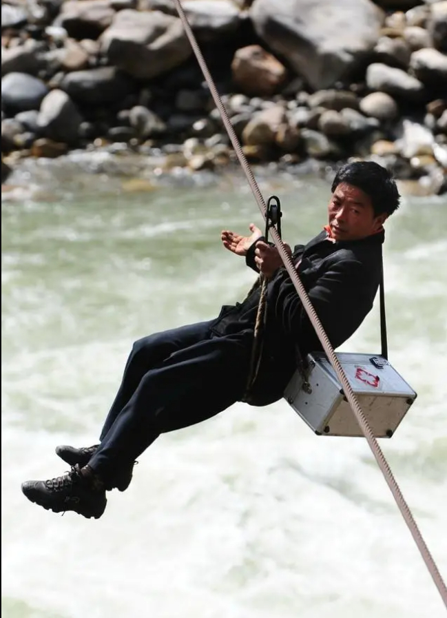 2011年2月20日，“溜索医生”邓前堆在拉马底村溜索到江对岸出诊。新华社记者 秦晴 摄