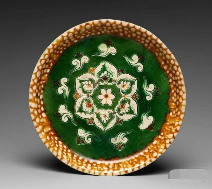 藏于美国大都会博物馆的唐代三彩宝相花纹盘，上面的“宝相花”就把很多花卉形象融合在一起的理想花卉。                   