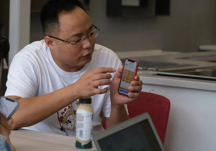 ▲邱大川在介绍“附近搜搜”小程序。受访者供图