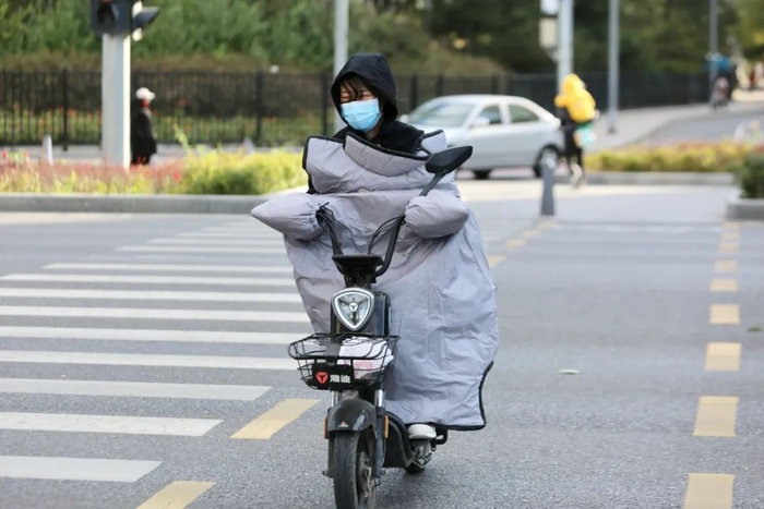 ▲天宫院，路人头发被风吹乱，非机动车上也装上了防风装备。