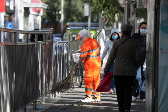 ▲西四环南路，环卫工人及时清扫大风吹落的树叶。