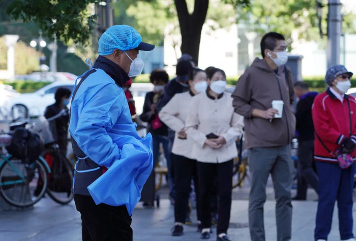 ▲广渠门内大街核酸检测点，工作人员在大风中维持秩序。