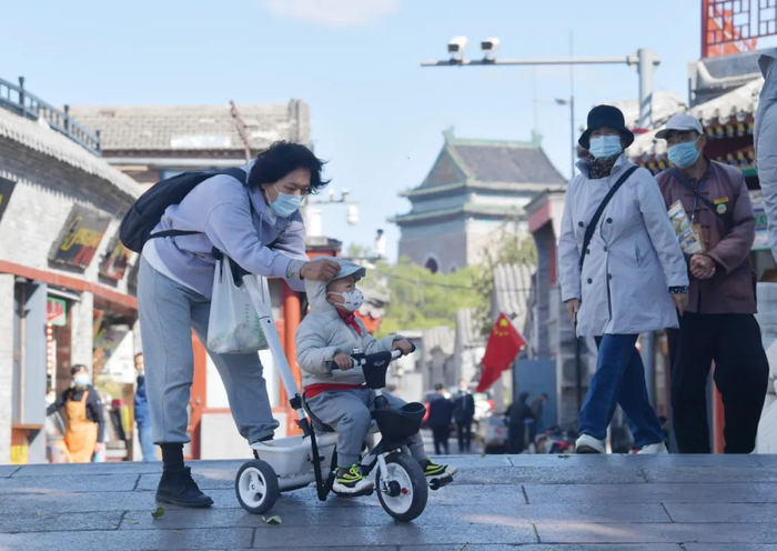 ▲银锭桥，家长为孩子戴帽子避风。