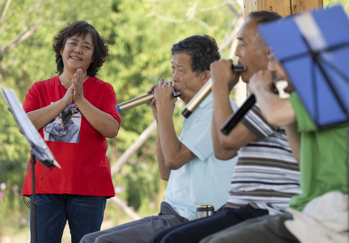 9月28日，久敬庄公园，丰台区和义街道居民林玉娟在公园凉亭里听居民吹口琴。新京报记者 陶冉 摄