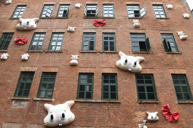 重庆街头一房屋外墙布满了猫咪外形和蝴蝶结样式装饰物。 周毅 摄