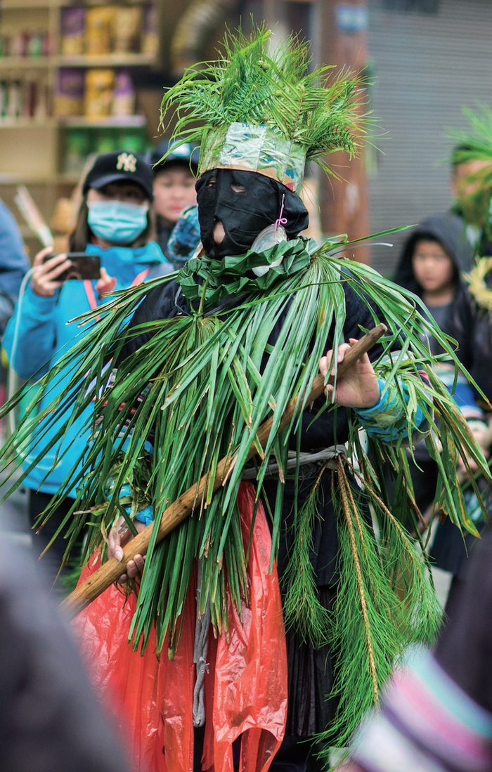 还有人脸上涂满黑色锅灰，在头部与身上捆绑绿叶，身披蓑衣，远远看去像个稻草人。