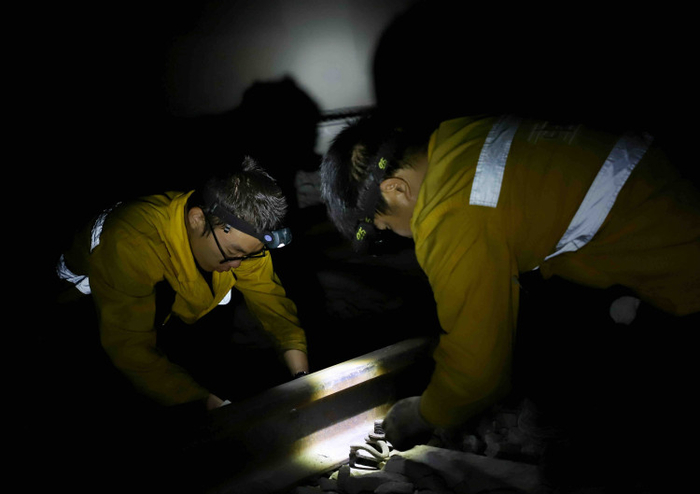 职工正在珞璜东站至南彭站区间陈家湾隧道内安装线路零配件               罗浪  摄