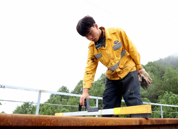职工正在对线路轨距进行复核                 罗浪 摄   