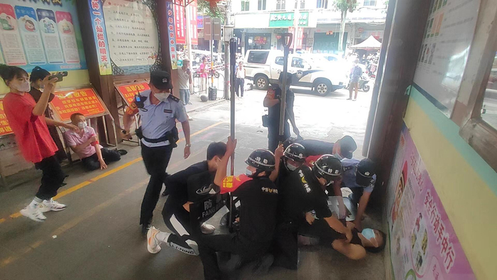 手持“凶器”的“歹徒”被众保安“制服”在地。受访者供图