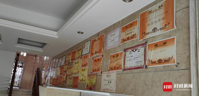 庞钰千家中，半壁墙贴满了她的各种奖状。