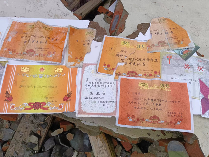  10月18日，罗永再次回到湾东村，在废墟了翻出了女儿的奖状，他觉得很欣慰。受访者供图