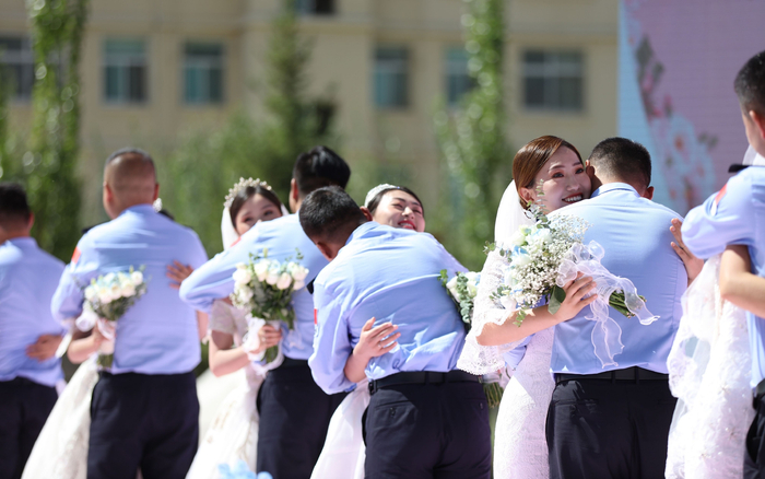 　　8月5日，西藏出入境边防检查总站举办“边守·边爱”集体婚礼，现场民警与“警嫂”相互拥抱在一起。胡俊浩 摄/IC photo