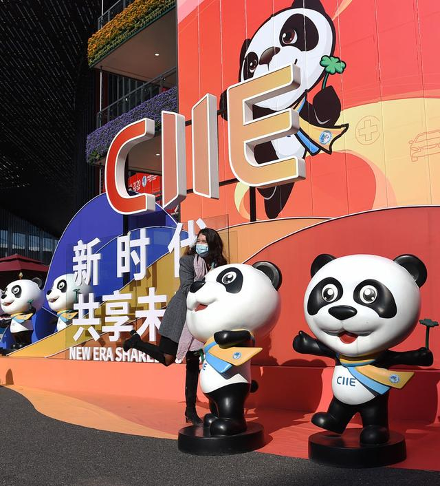 2020年11月10日，一名外国参展者在一处进博会主题装饰前拍照留念。新华社记者 赵丁喆 摄