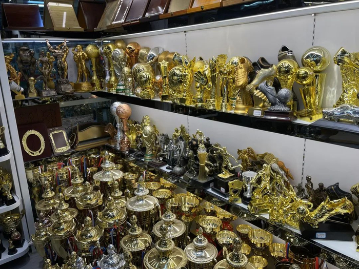 ▲世界杯热潮来袭，奖杯、徽章等纪念品生意火热。
