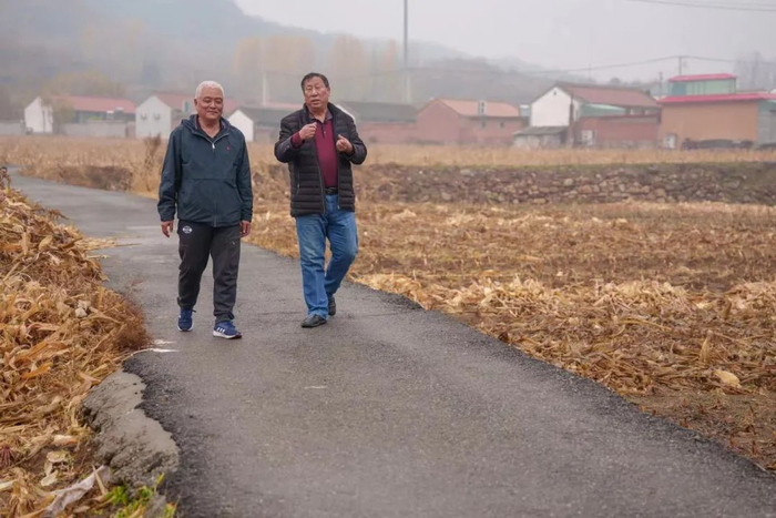 　　▲10月26日，密云区大城子镇墙子路村，高克昌（左一）和王瑞胜走在村间小路上，他们边走边商量着今天的采访选题如何呈现。新京报记者 王子诚 摄