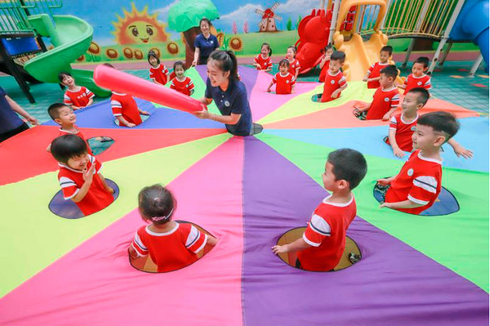 ▲2022年7月28日，河北省遵化市一所幼儿园的老师组织暑期托管班的孩子们做游戏。图/新华社