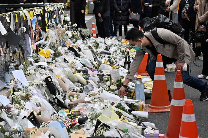 当地时间2022年11月3日，韩国首尔，一名男子在梨泰院地铁站外的一个临时纪念碑前献花。视觉中国 图
