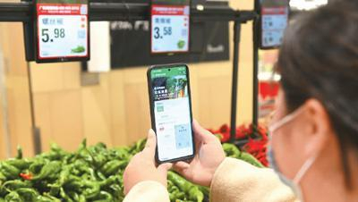 安徽省阜阳市市场监管局在颍东区大中型商超开展食用农产品“码上见”食品安全追溯体系建设试点，消费者通过手机扫码就能清晰看到食品的原产地、质检报告、供货企业的经营资质等信息。图为市民在颍东区永辉超市世纪金源店蔬菜专区利用手机扫码了解蔬菜详细信息。王 彪摄（人民图片）