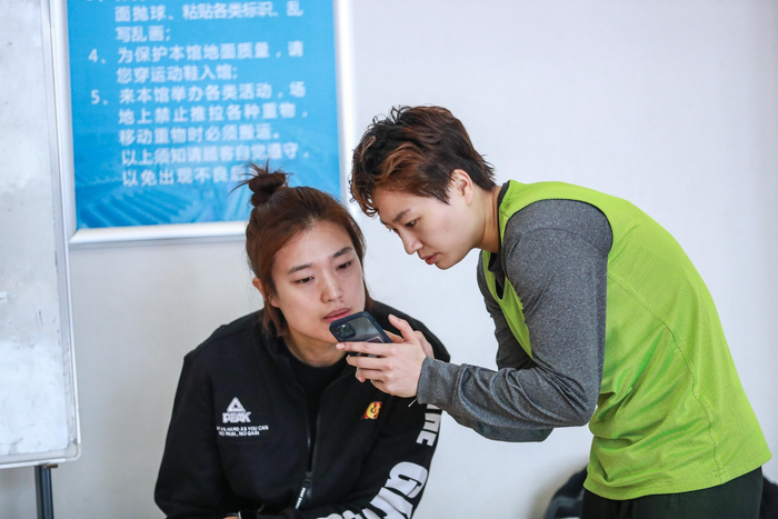张绮芳（右）与首钢女篮主教练张琳交流。  图/北京首钢篮球俱乐部