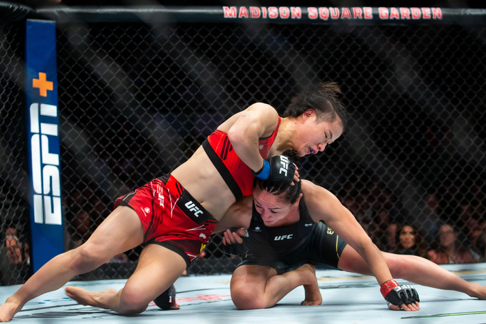 张伟丽（左）与卡拉在地面相持中不落下风。 图/新华社