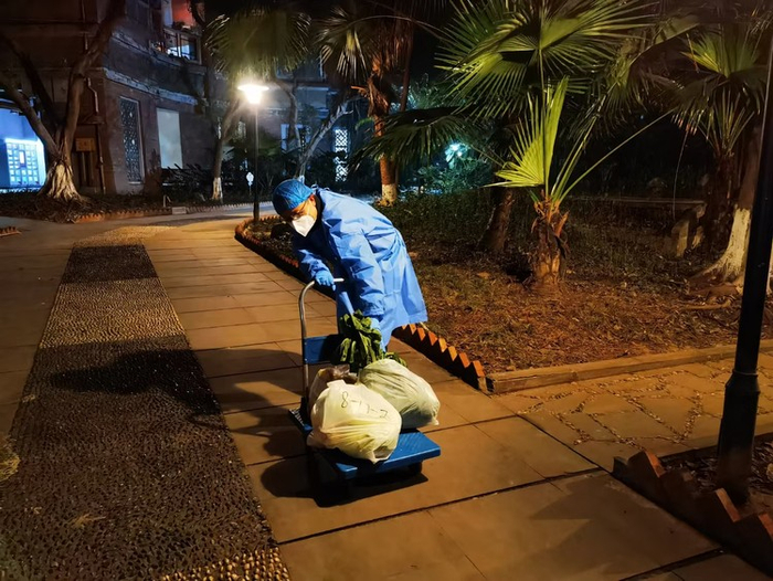 ▲拉着拖车为居民送菜的杨睿