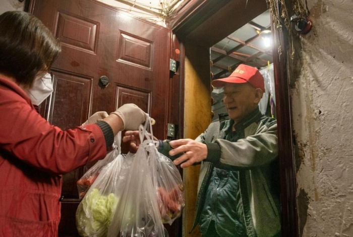 ▲ 江北区嘉陵三村，多多买菜团长钟祖芳为老人送货上门/图源 张锦辉