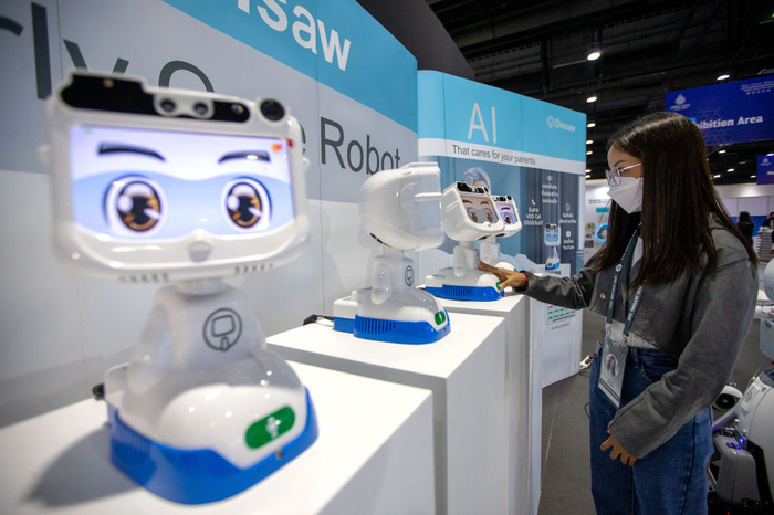  11月14日，在泰国首都曼谷，工作人员在APEC会议媒体中心与机器人互动。新华社记者 王腾 摄