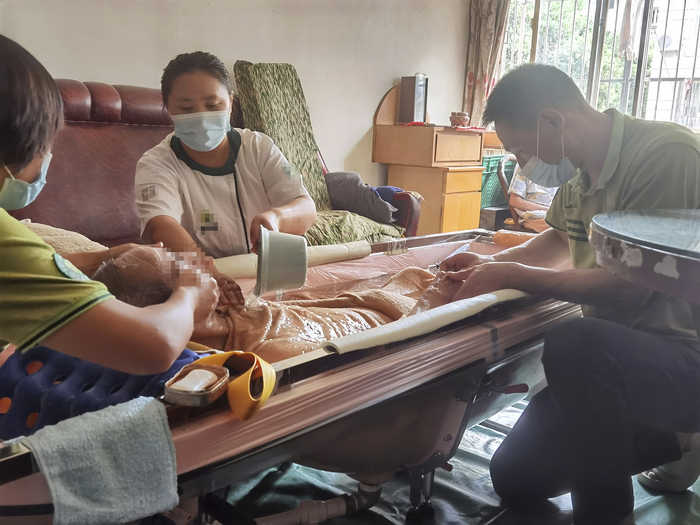 9月24日，助浴师们为夏雪明洗澡。