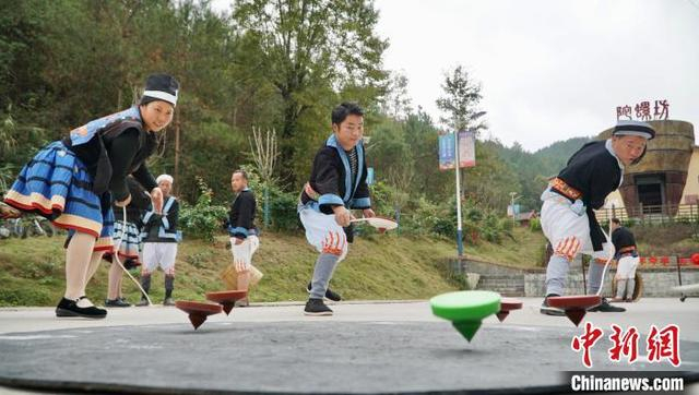 三名白裤瑶居民同时将陀螺甩出。 韦国政 摄