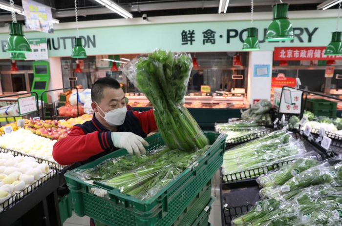 ▲2022年11月23日，京客隆劲松店工作人员正在给蔬菜区上货。新京报记者 王飞 摄