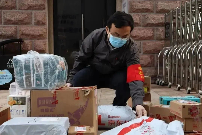 志愿者帮居民配送快递。两江新区人和街道供图