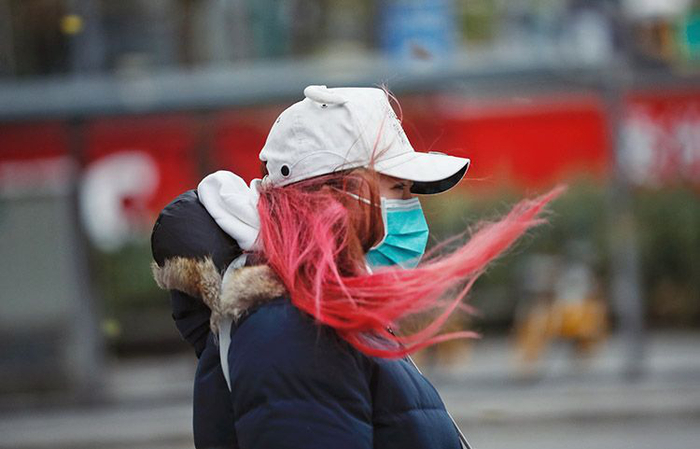 朝阳路，一位女士的头发被大风吹起。图片来源：新京报