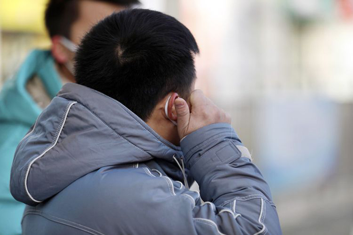 11月29日，西四环南路辅路，一位市民揉搓着冻红的耳朵。图片来源：新京报