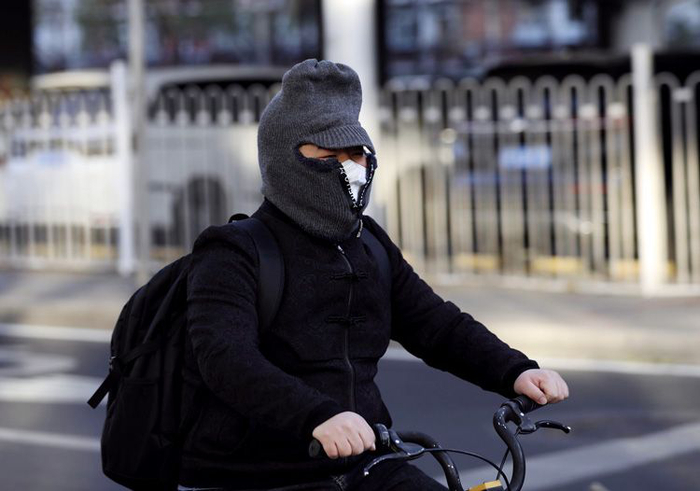 11月29日，西四环南路辅路，一位市民缩着手扶住冰凉的车把。图片来源：新京报