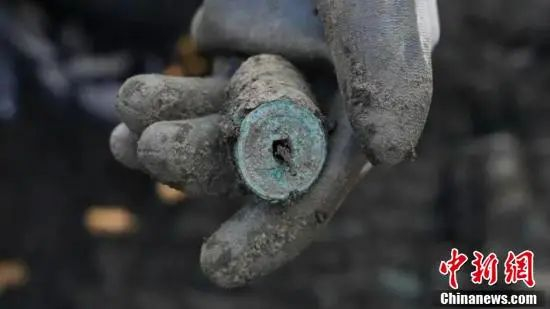 考古工作者展示发掘出的钱币