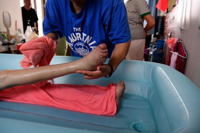 陈泽英在帮一位老人擦洗身体。武晓瑜 摄