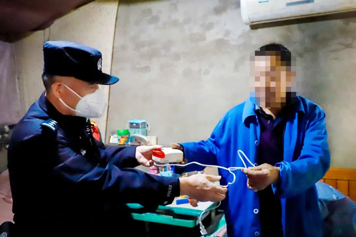 民警给住户发放一氧化碳报警器。海淀警方供图