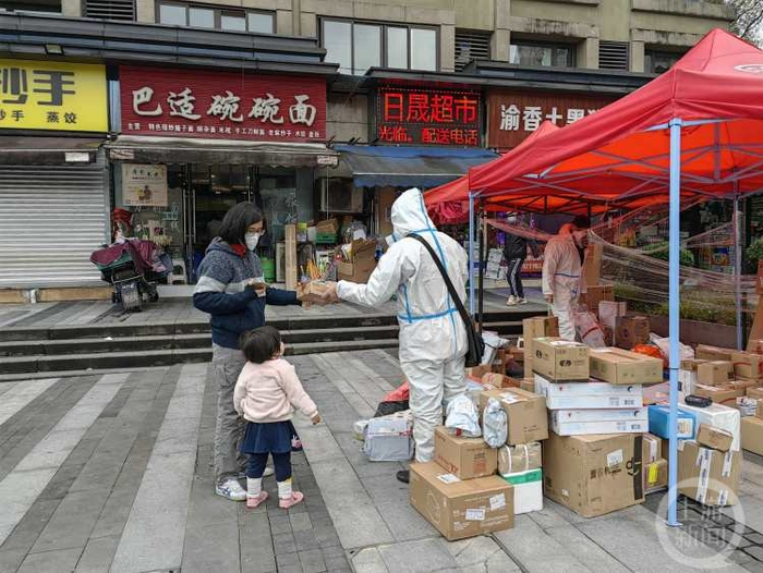 ▲12月2日，两江新区，一位母亲带着孩子出小区拿快递。上游新闻记者 陈竹