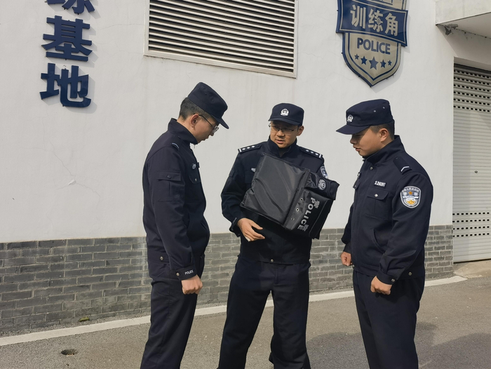王宁（中）向同事介绍警用多功能腰带使用方法。受访者供图